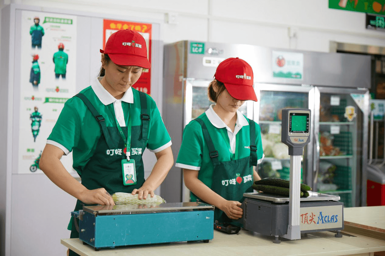 Two ladies selling fresh produce in a grocery store.