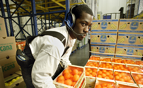 Warehouse worker moving oranges. Photo credit: Global Cold Chain Alliance.
