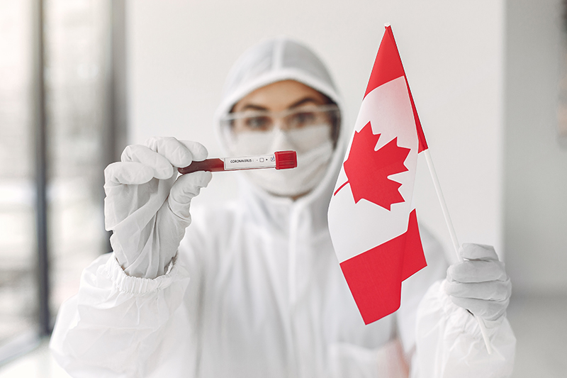 The scientist in coverall suit with a coronavirus sample and Canadian flag. Copyright: Freepik/@prostooleh.