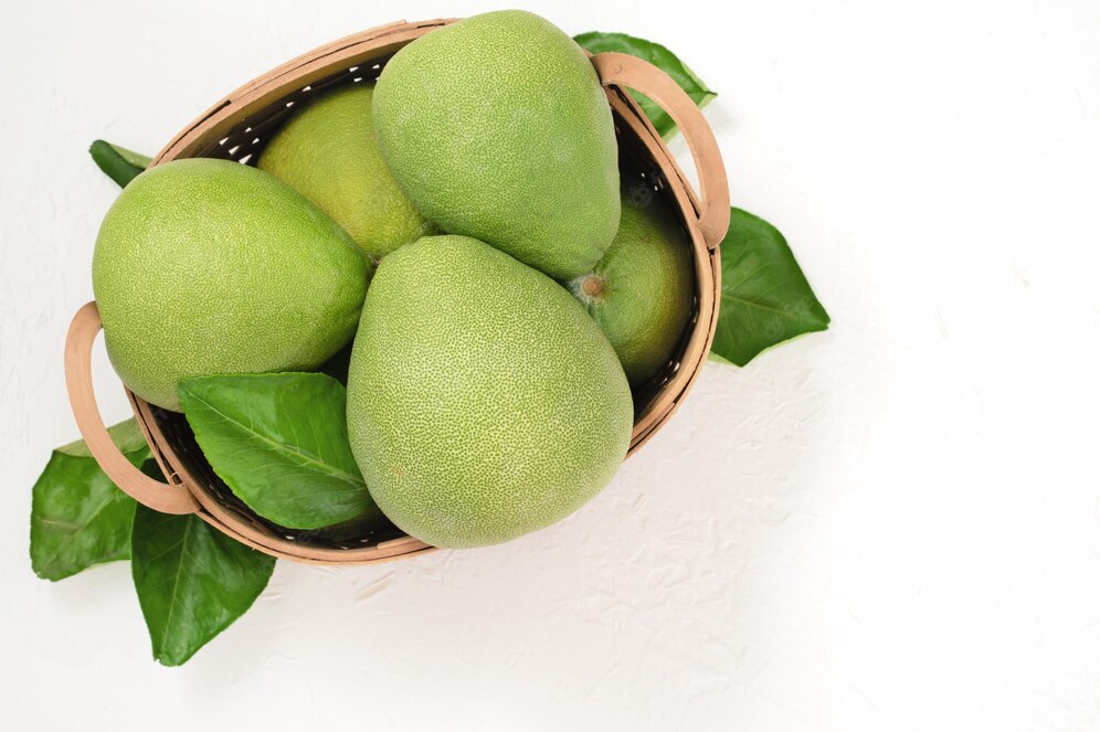 Fresh pomelo, pummelo, grapefruit, shaddock on white cement background in bamboo basket. Copyright: romiximage/Freepik.