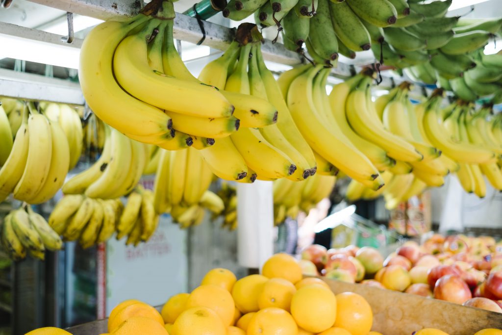 Banana hanging in market. . Copyright: Jcomp/Freepik.