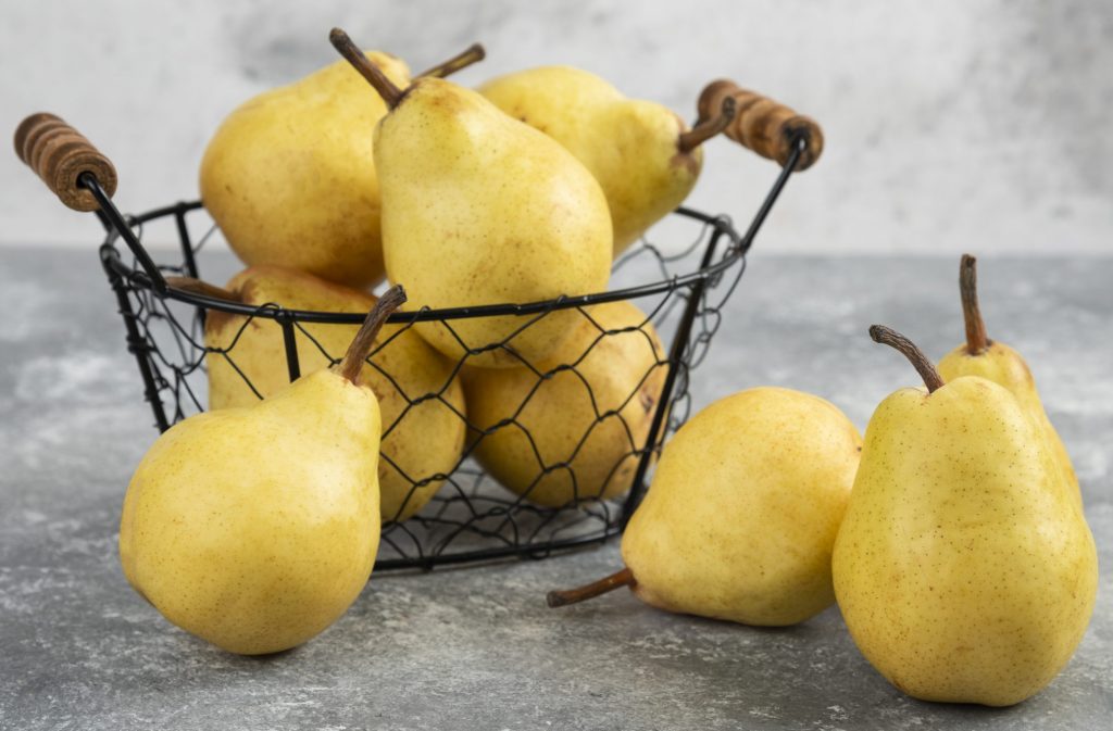 Bunch of fresh yellow pears in metal bucket on marble surface. Copyright: Azerbaijan Stockers.